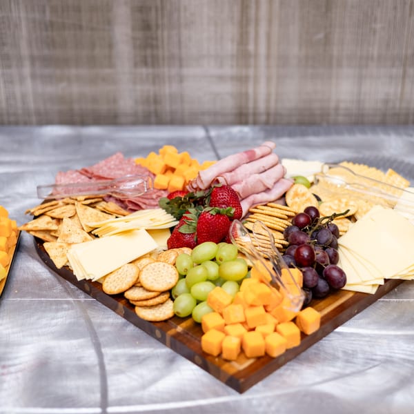 Heart-shaped charcuterie board with meats, cheeses, grapes and strawberries