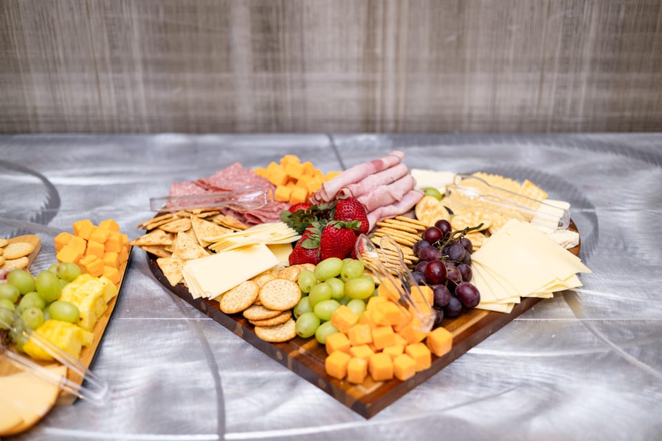 Heart-shaped charcuterie board with meats, cheeses, grapes and strawberries